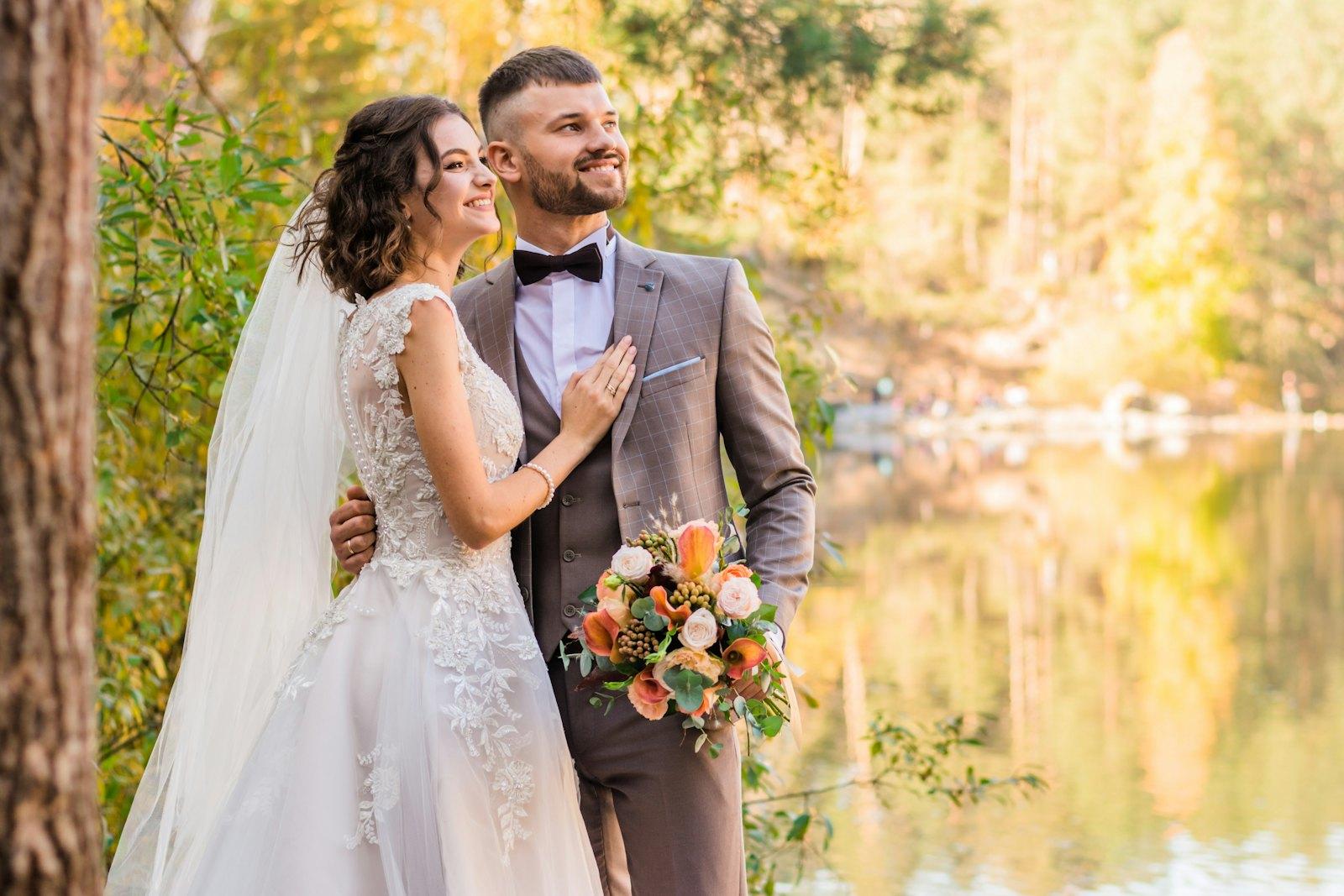 Priya and Dan by the lake, dressed for their wedding