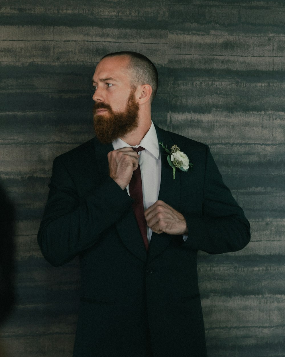 Zack in a dark suit, photographed against a soft backdrop